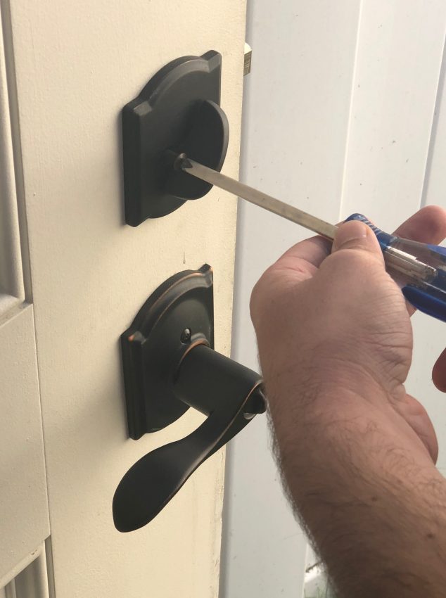 Professional locksmith changing locks on a door